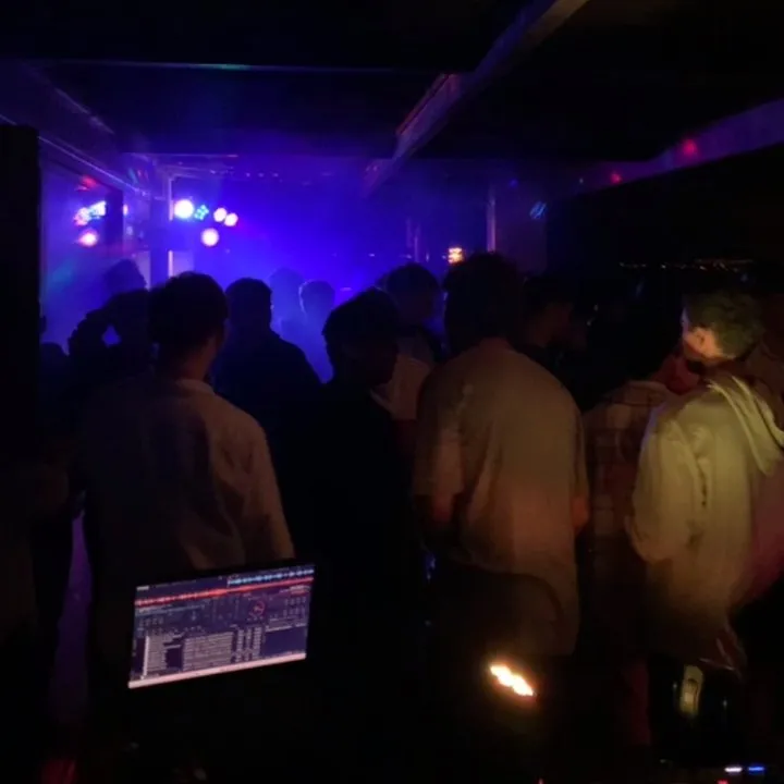 Pista llena con iluminación y DJ